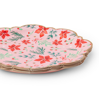 Stack of pink floral Christmas paper plates showing the scalloped gold-trimmed edge and floral pattern from an angle.