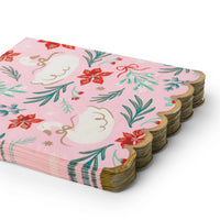 Stack of folded pink swan Christmas paper napkins showing the floral print and gold scalloped edge from an angle.
