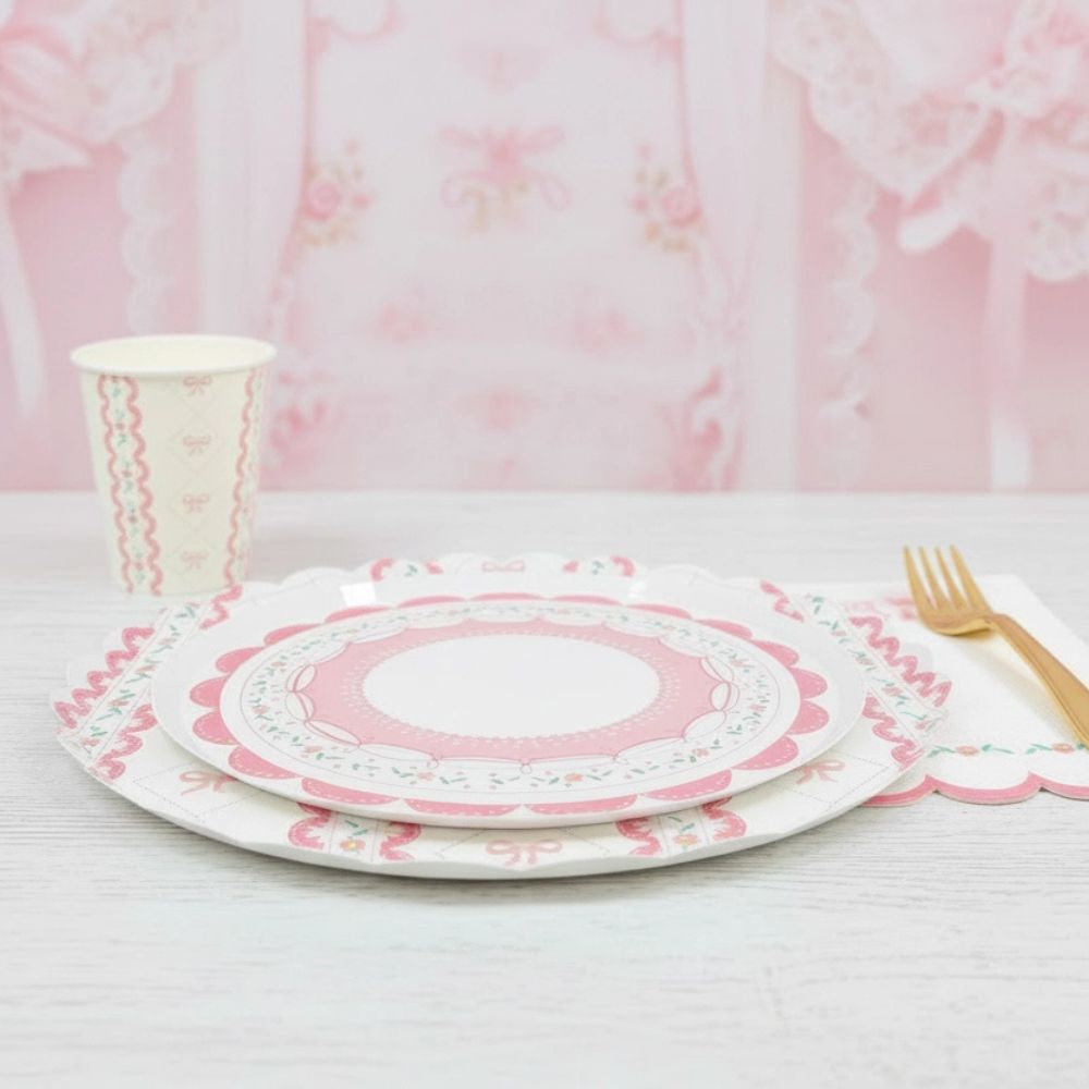 Side view of a pink coquette plate with matching cup and gold fork