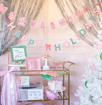 Pink and green Christmas dinner napkins styled at a party backdrop