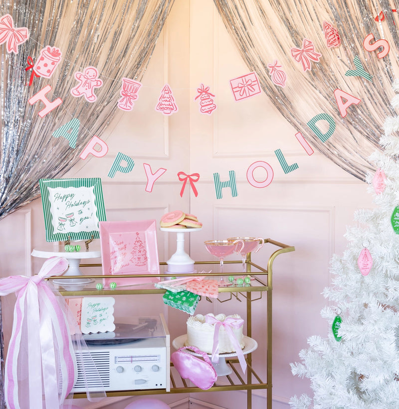 Pink and green Christmas dinner napkins styled at a party backdrop