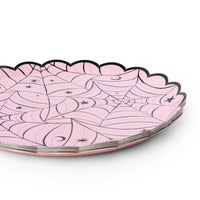 Close-up of the pink scalloped Halloween plate showing the spiderweb design and scalloped gold edge.