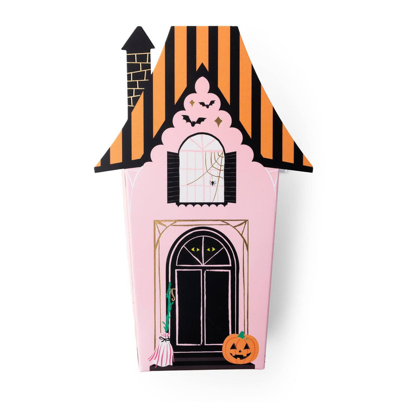 Angled view of the assembled pink haunted house favor box showing the arched door, gold-foil window, pumpkin, and striped roof detail.