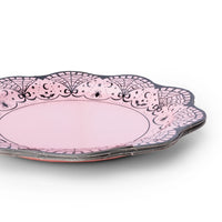 Stack of pink lace-border Halloween plates showing the scalloped edge and spiderweb design.