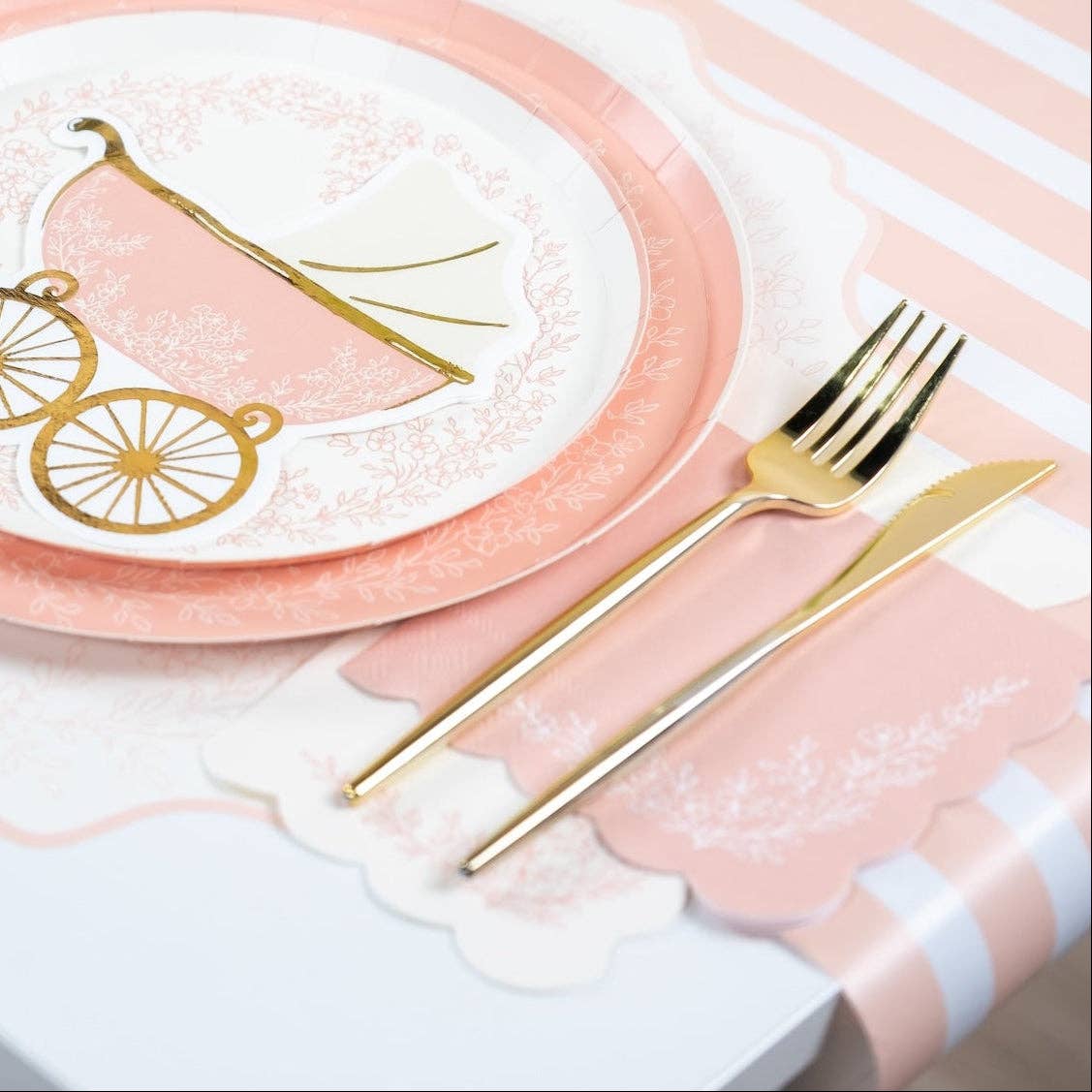 Close-up of pink floral napkin with gold fork and knife