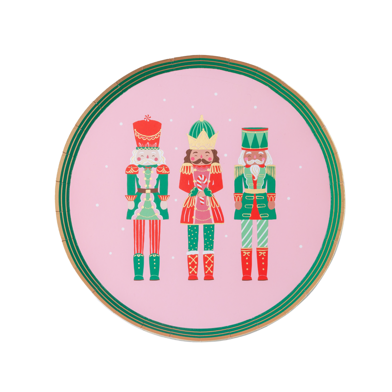 Flat pink Nutcracker dessert plate with three pink-and-red nutcracker soldiers, gold-foil accents, and a green-and-gold rim.
