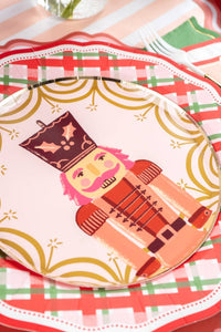 Close-up of a pink nutcracker plate layered on the plaid dinner plate.