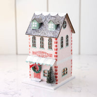Angled view of the pink patisserie house on marble showing the side windows and dormered roof