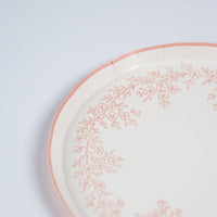 Close-up of scalloped edge on pink floral dessert plate