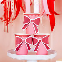 Valentine party table styled with pink and red bow paper cups