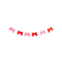 Pink and red felt bow banner strung on cream ribbon for Valentine’s Day party decor