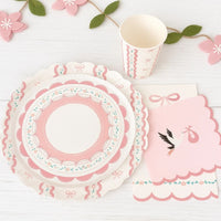 Pink baby shower setting with stork napkins and bow themed tableware