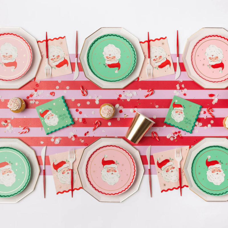 Retro Christmas table with pink Santa napkins, Santa plates, striped runner and gold cups