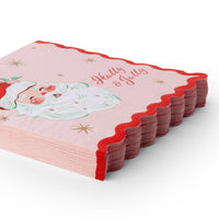 Angled stack of pink Santa paper napkins showing the red wavy scalloped edge