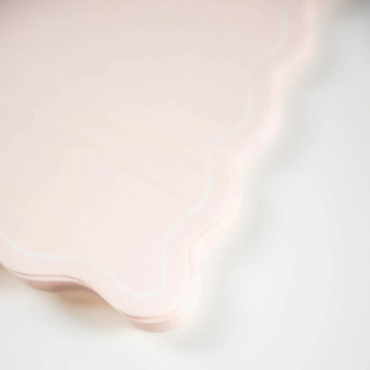 Close detail of scalloped edge on blush guest towel.