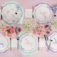 Pastel unicorn tablescape with blush pink paper napkins tucked at each setting
