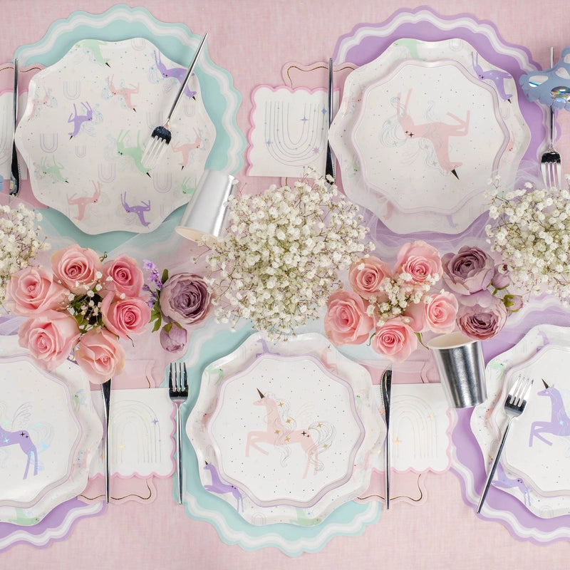 Pastel unicorn tablescape with blush pink paper napkins tucked at each setting