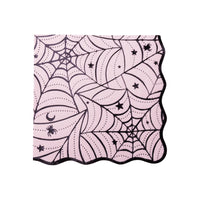 Pink Halloween napkin with a black spiderweb print, stars, a moon, and a spider, finished with a wavy edge.
