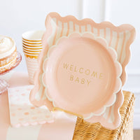 Pink striped party plates styled for baby shower table