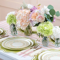 Pink striped table runner styled with pastel tableware and flowers