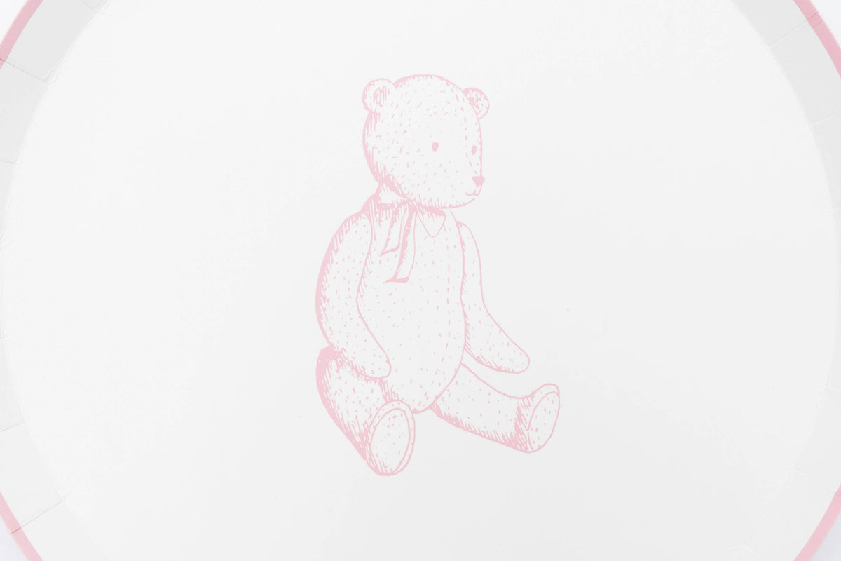 Detail of the pink sketched teddy bear with a ribbon bow at its neck on a white paper plate