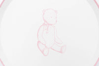 Detail of the pink sketched teddy bear with a ribbon bow at its neck on a white paper plate