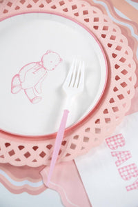 Close view of a pink teddy bear paper plate on a pink lattice charger with a pink fork