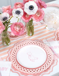 Pink baby shower table with pink teddy bear plates, ranunculus, anemones, and peonies in bud vases