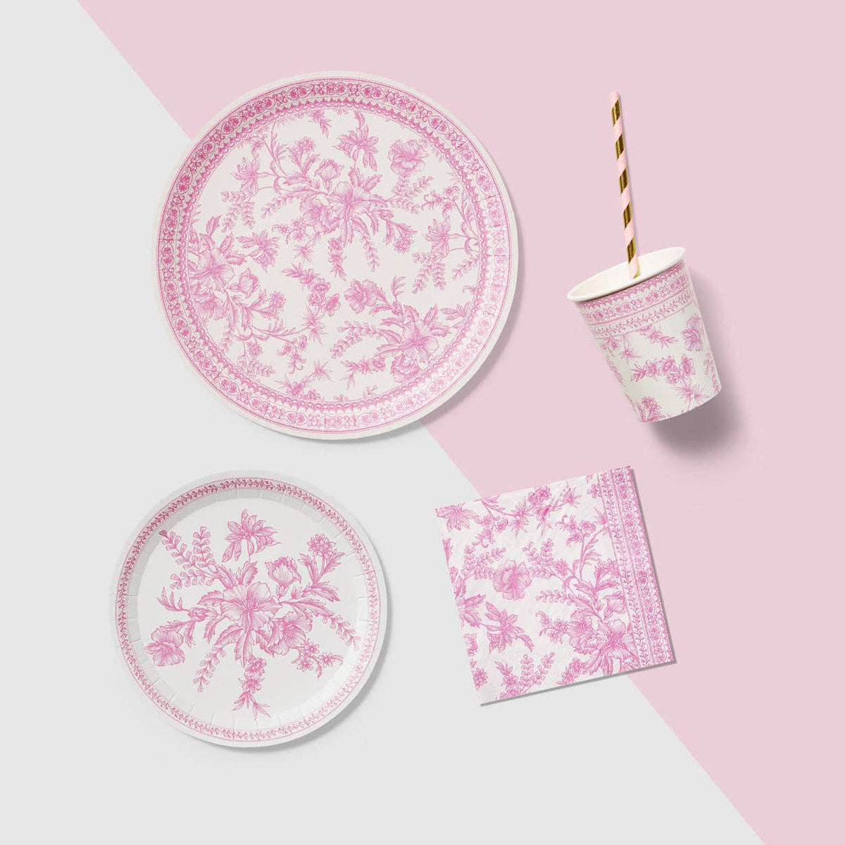 Pink toile plate with matching napkin and cup on styled background.