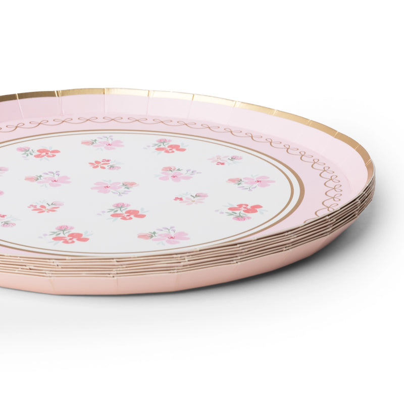 Stack of pink watercolor floral dessert plates showing the scalloped gold rim and floral print from an angle.