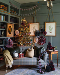 Plaid honeycomb Christmas trees styled on a shelf with paper fans and a banner