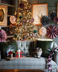 Plaid paper chain styled across a sofa with gifts