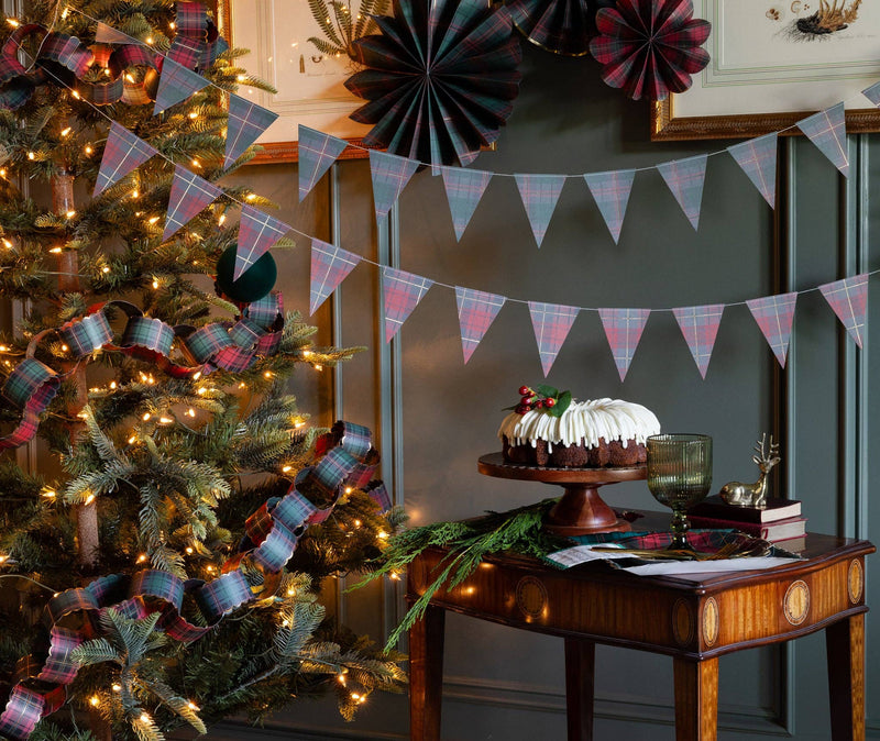 Plaid pennant banner styled with paper fans by a Christmas tree
