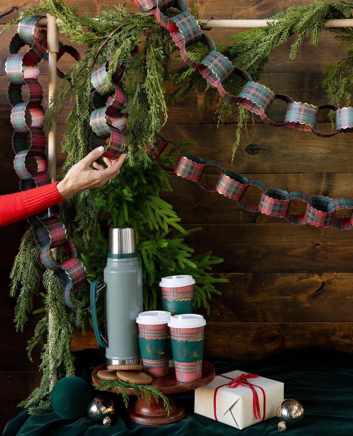 Plaid to go cups styled on a counter with a paper chain and thermos