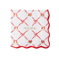 Polar Express Believe napkin with a red ribbon lattice, golden bells, and a scalloped red edge