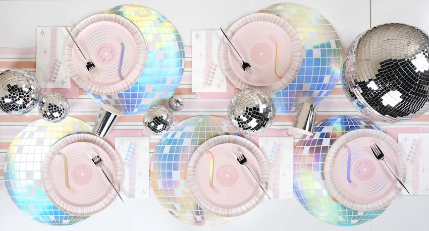 Overhead view of a stadium-tour chic table setting with holographic disco ball placemats and record plates.