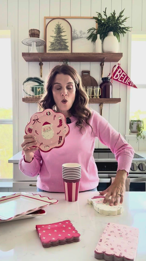 Woman showing St. Nick Shaped Dinner Napkins with coordinating Christmas tableware