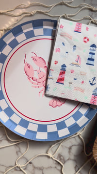 Seaside products like lobster plates and seaside napkins along with a lobster themed dessert.