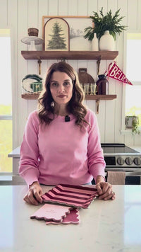 Woman showing Pink and Burgundy Striped Plates with matching Christmas tableware