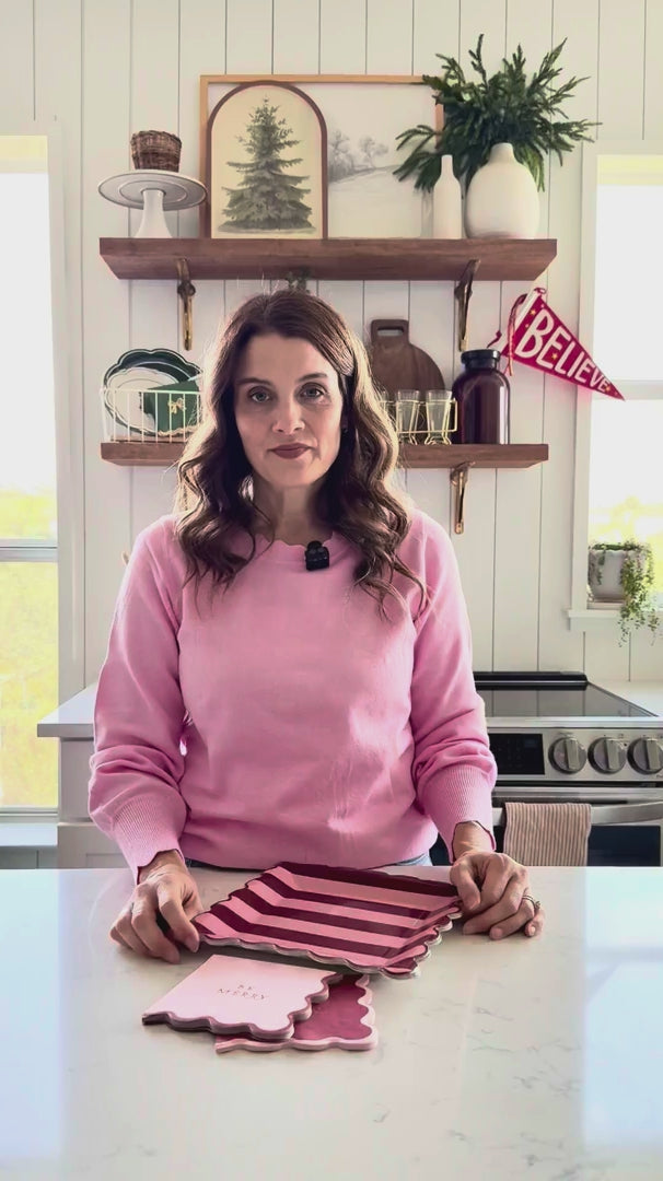 Woman showing Pink and Burgundy Striped Plates with matching Christmas tableware