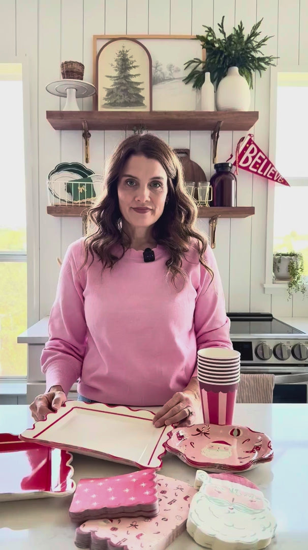 Woman showing Cream Scalloped Paper Plates with coordinating Christmas tableware