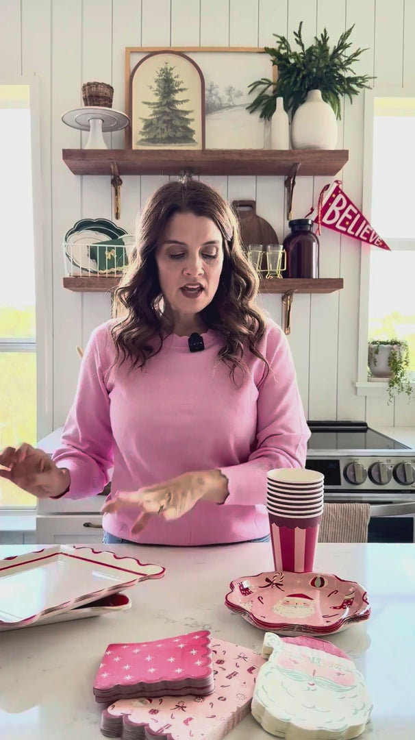 Woman showing St. Nick Icon Paper Plates with coordinating Christmas tableware