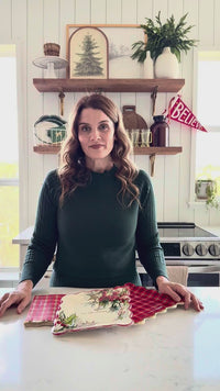 Woman showing Red Plaid Scalloped Christmas Plates with coordinating holiday tableware
