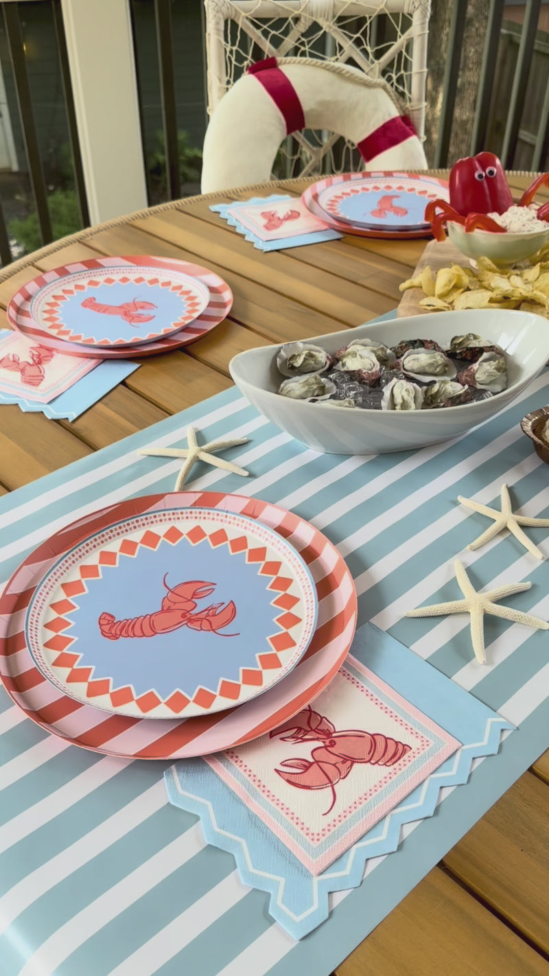 Seaside themed products like lobster plates, napkins, table runners, and foods. 