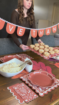 Setting up a Thanksgiving table with the Woodland Thanksgiving party kit, layering rust, ric rac, and woodland plates with napkins and the bamboo tray