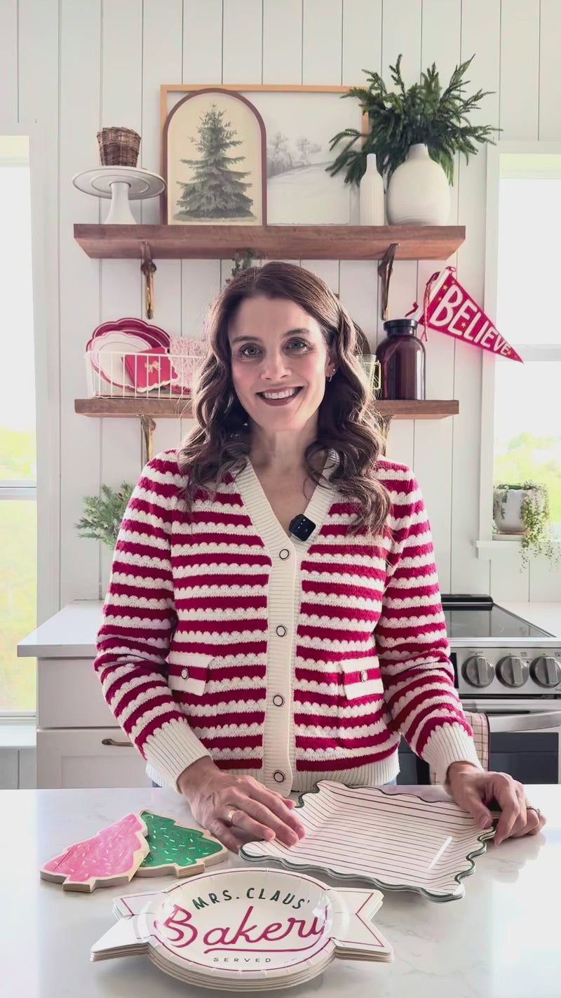 10–15s styling reel showing Mrs. Claus Bakery 9" square striped paper plates layered on a cookie bar; demonstrates size, scalloped rim, and how they complete a Christmas paper plates setup.