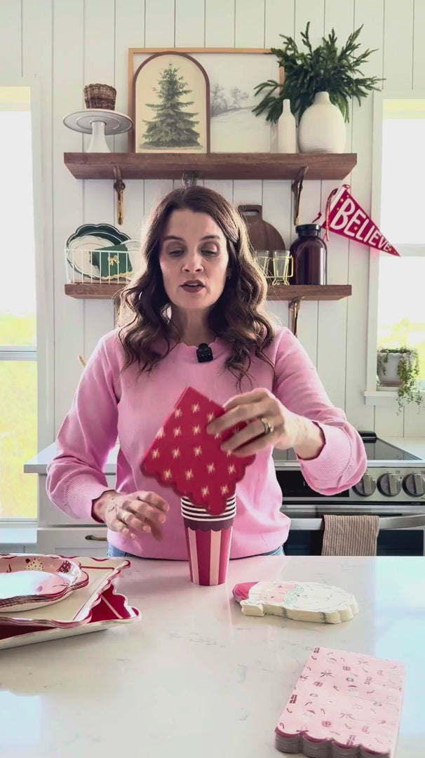 Woman displaying Red Star Christmas Paper Napkins with coordinated tableware