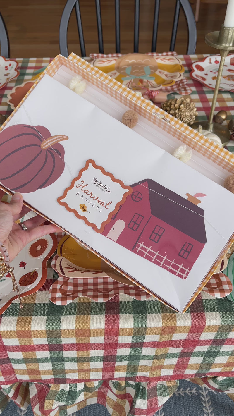Thanksgiving garland with cream and tan pom poms and illustrated paper turkey, pumpkin, barn, pie, corn and apple basket cutouts