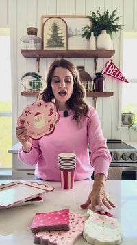 Woman displaying St Nick Paper Dinner Napkins with coordinating Christmas tableware