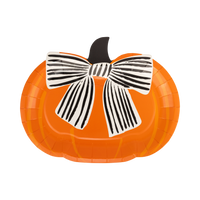 Die-cut orange pumpkin shaped Halloween paper plate with a large black-and-cream striped bow and dark stem, front view on white background.